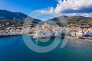 Amazing aerial panorama photo of Cadaques small cizy city by the sea in Spain. Sunny day and big clouds. Mountains