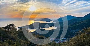 Amazing aerial view of beautiful sunset Blue Lagoon in Oludeniz, Turkey. Summer landscape with beach and mountains