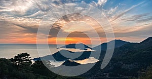 Amazing aerial view of beautiful sunset Blue Lagoon in Oludeniz, Turkey. Summer landscape with beach and mountains