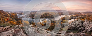 Amazing aerial view of mountain rocks, blue foggy river and colorful forest on sunrise. autumn landscape