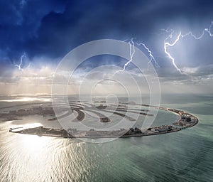 Amazing aerial view of Palm Jumeirah Island in Dubai from helicopter against sunset sky