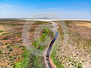 Amazing aerial view of small red water river leading to Baskunchak