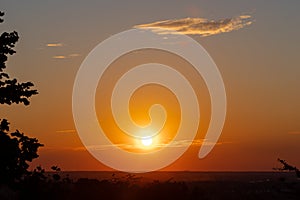 An amazing African sunset over the rolling hills in Bemelen, south Limburg, with the sun as a yellow ball of fire and an orange sk