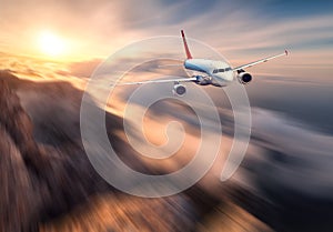 Amazing airplane mith motion blur effect is flying over low clouds