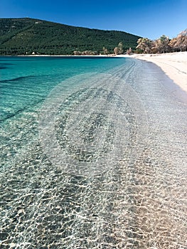 Amazing Alghero, Sardinia, mediterranean sea, Mugoni Beach, sunny summer day, walking on the shore. White sand and clear sky