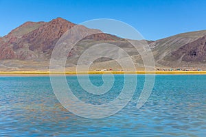 Amazing Altai natural landscape, calm lake with emerald water, surrounded by incredible mountain ice peaks with a gloomy, cloudy