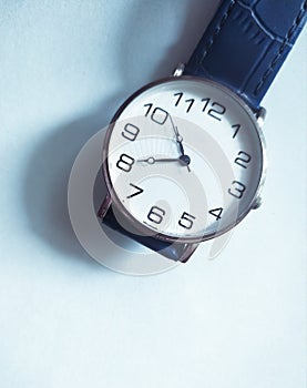 Amazing analogue wrist watch isolated in elegant light blue background