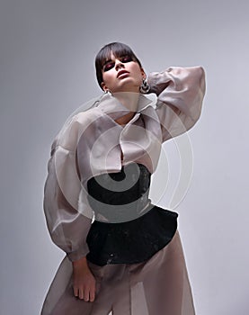 Amazing asian beautiful woman with bob stright black hair style posing in fashion silk clothing on gray background. Closeup