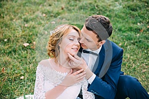 Amazing attractive young couple in wedding day. the bride in a cute white dress, the groom in a blue fashionable