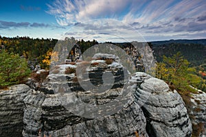 Amazing autumn landscape in Saxon Switzerland National Park. View of exposed sandstone rocks and forest hills at sunset. Germany.