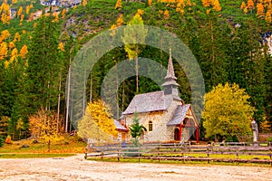 Amazing autumn scenery of small chapel at Lago di Braies Lake, Dolomite Alps, South Tyrol, Italy