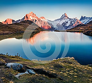 Amazing autumn sunrise on Bachsee lake with Wetterhorn and Wellhorn peaks on background. Colorful autumn morning in Bernese Oberla