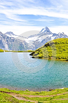 Amazing Bachalpsee lake in the Swiss Alps photographed with famous mountain peaks Eiger, Jungfrau, and Monch. Alpine lake and