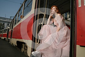 Amazing beautiful red-haired young woman in retro style fancy prom pink dress