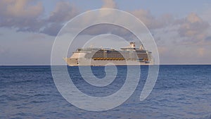 Amazing beauty Atlantic ocean turquoise water surface. Big cruise boat merging with blue sky and white clouds. Aruba island.