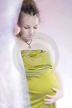 Amazing beauty pregnant woman behind curtain