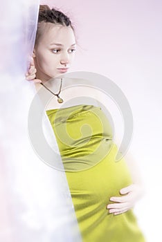 Amazing beauty pregnant woman behind curtain