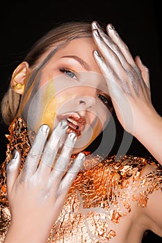 Amazing blonde model with professional makeup and gold foil on h