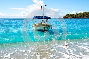 Amazing blue sea on Oludeniz beach with fish boat in Turkey