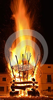 amazing blur effect of a violent bonfire of fire in a village in the dark night. The combustion creates big flames, flares, smoke