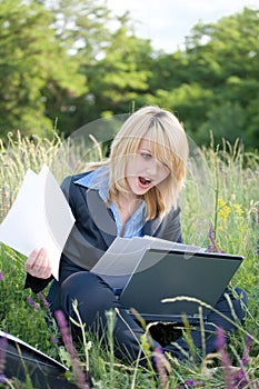 Amazing businesswoman on grass with documents