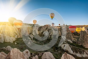 Amazing Cappadocia rocky landscape and balloons at sunrise, view of the valley and canyons
