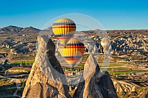 Amazing Cappadocia rocky landscape and balloons at sunrise, view of the valley and canyons