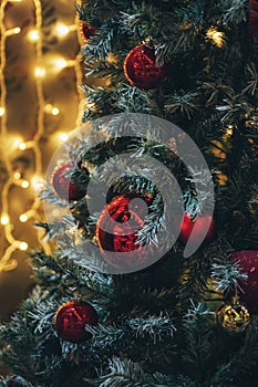 Amazing Christmas decorations on fir tree with red balls and Christmas lights, blurred background