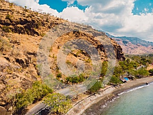 Amazing cliff with rocks, road and sea in Northern Bali. Aerial view