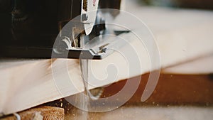 Amazing close-up, focus shifts on rotary buzzsaw carefully cutting a piece of wood, carpenter at work slow motion.