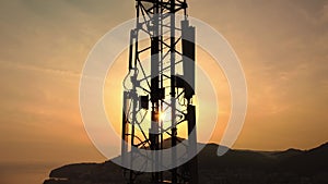 Amazing closeup sunset drone view of silhouette of cell tower. Wireless connection. Spectacular view of cellular tower
