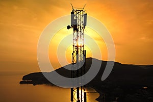 Amazing closeup sunset drone view of silhouette of cell tower. Wireless connection. Spectacular view of cellular tower with