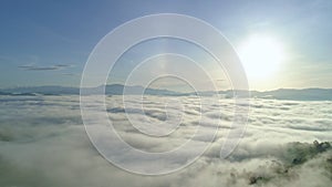 Amazing clouds of dense fog move flowing over mountain Sunrise or sunset sky fog scenic aerial view.Drone flies over sky Rainfores