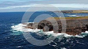 Amazing coastal scenery. Blue ocean water crashing on rock cliffs on sea coast. Kilkee Cliff Walk, Ireland