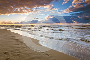 Beatiful sunset with clouds over sea and beach