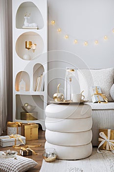Amazing composition on white design shelf with christmas decoration, lights, gifts, lanterns ,deer, candles, stars, white corduroy