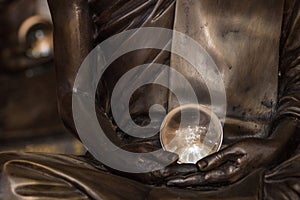 Amazing crystal ball in hands of monk statue