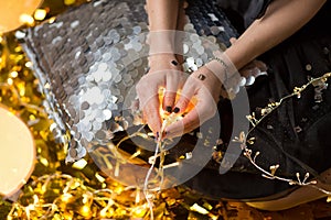 Amazing cute lady celebrating new year birthday party, posing in gold shine background and throwing colorful confetti with silver