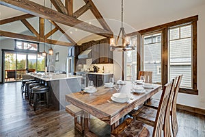 Amazing dining room near modern and rustic luxury kitchen with vaulted ceiling and wooden beams, long island with white quarts