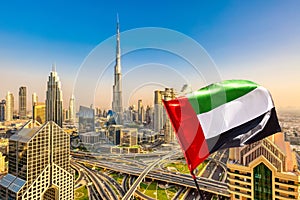 Amazing Dubai skyline cityscape with modern skyscrapers and UAE flag. Downtown of Dubai at sunny day, United Arab Emirates