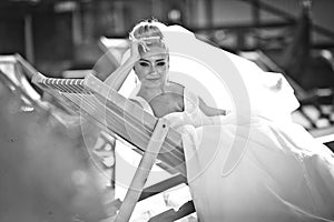 Amazing elegance cute stilysh blonde bride is posing on the bac