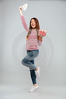 Amazing emotional young asian lady holding gift and money.