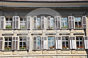 Amazing facade of the historical building in Bern, Switzerland. Decorated with flower boxes with traditional red geranium flowers