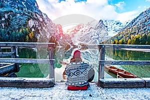 Amazing fascinating magical autumn winter landscape with a girl playing guitar over a lake on Fanes-Sennes-Braies natural park in