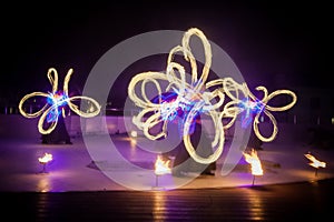 Amazing fire show dance. Fire dancers in beautiful costumes playing with colorful flames