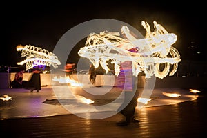 Amazing fire show dance. Fire dancers in beautiful costumes playing with colorful flames