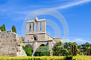 Amazing front side of ancient Bellapais Abbey in Turkish Northern Cyprus captured with the adjacent park and with blue sky.