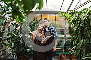 Amazing gardeners posing in the nature greenhouse garden work with flowers plants