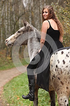 Amazing girl with long hair riding a horse