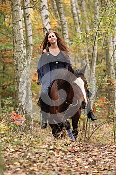 Amazing girl riding a horse without any equipment in autumn fore